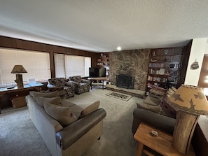 Large upstairs living room with two couches, two comfy chairs, TV & fireplace.