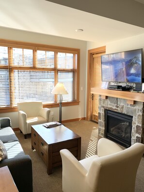 Open living room with gas fireplace and second balcony and LG 50" 4K smart TV.