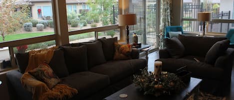 Living room area with view to green walking area. Large comfy couches. 