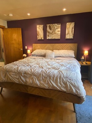 Primary bedroom, king herringbone wood bed, ensuite bathroom, deck + hot tub, 