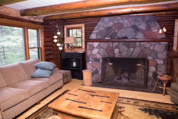 The living room is gorgeous with a fieldstone fireplace and view of the river.
