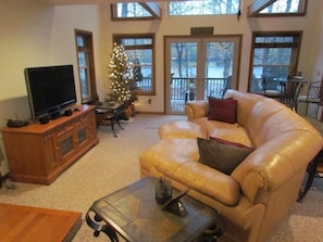 The comfortable great room with HD TV, stereo, leather couch, & high ceilings.