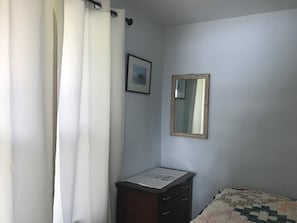 Small dresser in bedroom for storage.