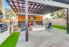 The backyard also features an outdoor TV, fire pit, and a grill
