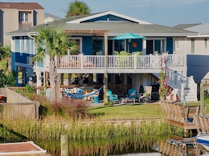 View from canal side - deck/Tiki bar overlook lawn, dock and canal.