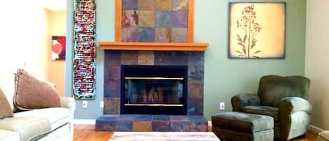 Cathedral ceilings in great room brings in light for the art and slate fireplace