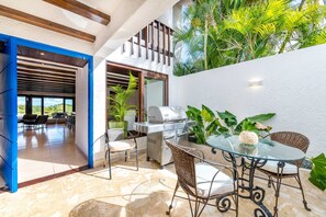 Outdoor courtyard with BBQ grill and seating area (bright blue front door!)