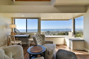 Full wall to wall windows line the living room area.