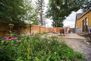 Backyard wildflowers and patio with table and chairs