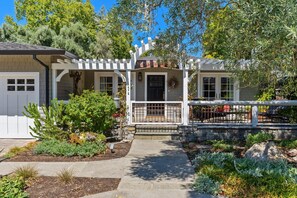 Charming craftsman bungalow with inviting front porch and lush landscaping.