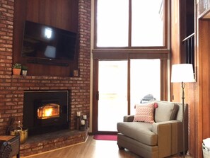 Living room w/ 55" TV, Pellet Stove (Fireplace), Love Seat, and balcony access