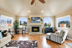 Living Room has comfortable sofa, big screen 3-D TV, fireplace and great views.