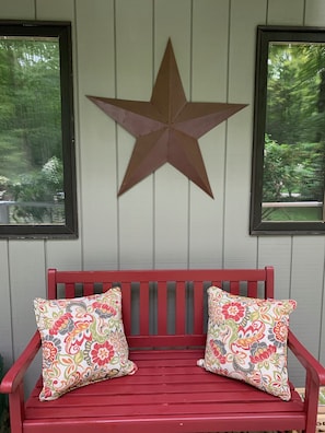 Seating on the front deck complements the home's country style.