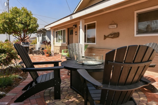 Enjoy the patio area with comfortable seating and a fire pit