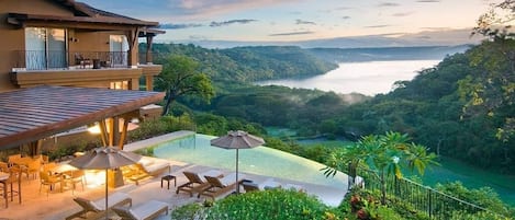 Overview of Vista Hermosa next to the infinity edge pool and views of Bahia Culebra, jungle, and golf course .