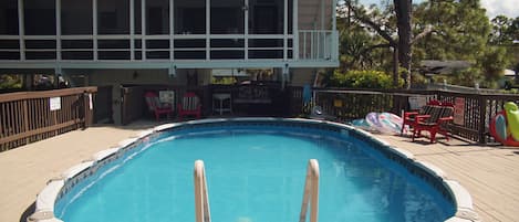 Ridiculously relaxing screened in porch overlooks large pool and huge pool deck.