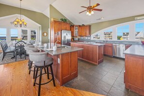 The large, tiled kitchen is a chef's dream with breakfast bar with second sink, ice machine, a JennAir® range, and 2 dishwashers.