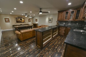 Game room- open bar, reclining leather sofa,  75" TV, billiards, shuffle board