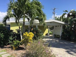 Driveway with carport and lush tropical yard