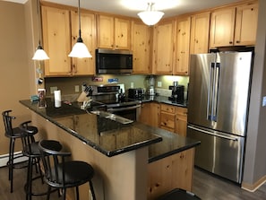 Kitchen with granite counters, stainless steel appliances and coffee station