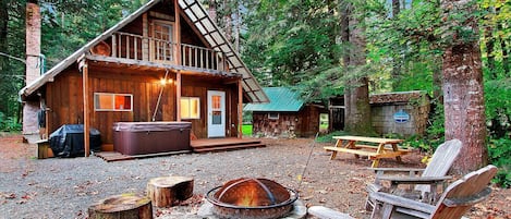 Backyard with fire pit, hot tub, and Weber gas grill. Laundry hut to the right.