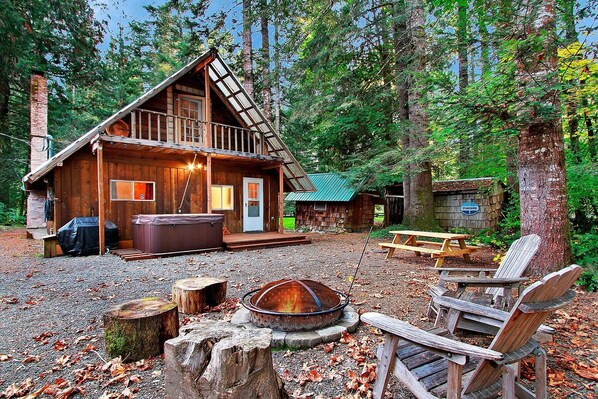 Backyard with fire pit, hot tub, and Weber gas grill. Laundry hut to the right.