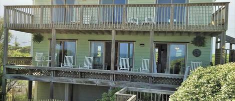 Oceanside view of cottage featuring two balconies and private access to beach.