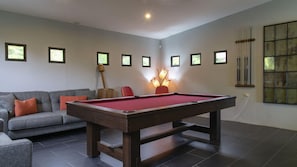 The game room features seating, pool, table, and a large-screen TV