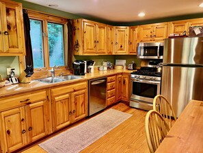 The kitchen is fully equipped with dinnerware, pots, pans,  stainless flatware