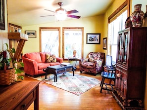 Living area with love seat, chair and Roku smart TV for streaming.