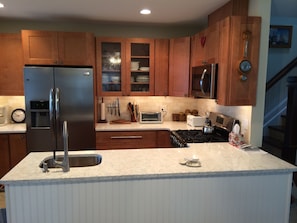 Kitchen, showing quartz counte rtops, SS appliances, dishwasher.