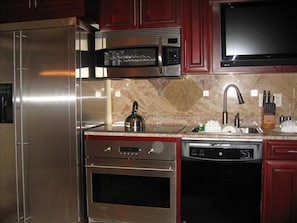 Full size kitchen appliances with oven and side by side fridge with ice maker