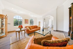 Living room with gas fireplace, bright, high ceiling, porcelain tile flooring