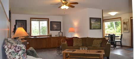 Living room, with fireplace, TV and several seats/chairs
