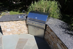 Outdoor kitchen with gas grill and sink.