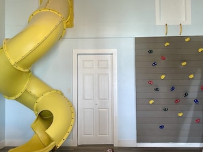 Rock wall into sleeping area & 10 ft slide. Unique indoor experience for kids.