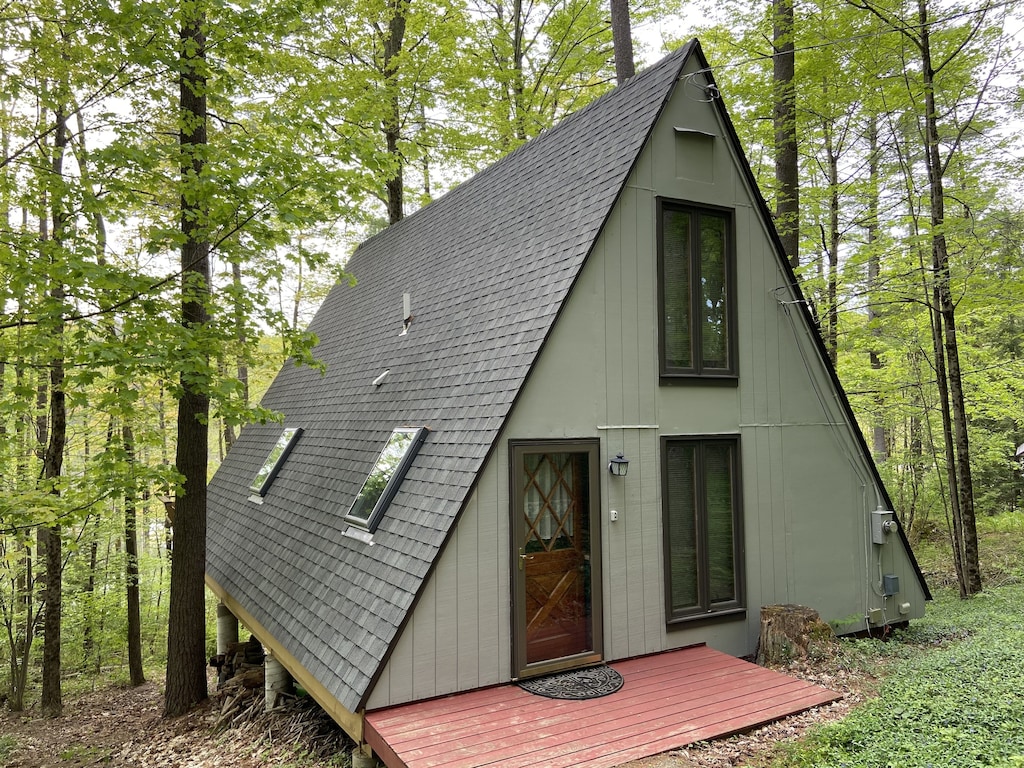 Exterior of A-Frame style house in the woods. 