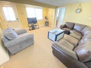 Living room has a chest to store things in and a pull out queen size sofa bed.