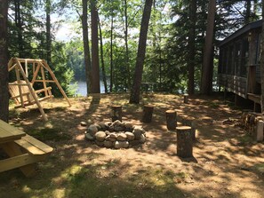 Side yard with swing, picnic table, and fire pit