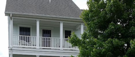 The front of our home with upper & lower porches overlooking a tree-lined street