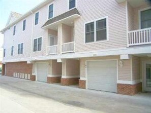 Rear of Town-home, driveway photo showing private garage and sm deck of bedroom.