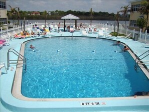 Large heated pool with plenty of chairs and a gazebo