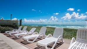 Sundeck by the pool, protected by the wind with frame less glass fence