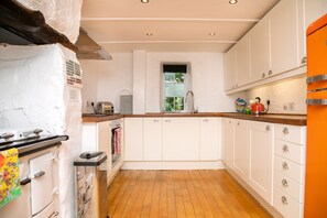 Kitchen with Rayburn, electric oven, hob, dishwasher and washing machine.