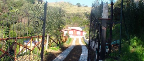 Ingresso chalet con cancello in ferro battuto  artigianale, staccionata e viale.