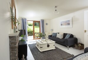 Curlews Cwtch, Roserrow. Ground floor: Stylish sitting room with comfortable sofas and direct access to garden