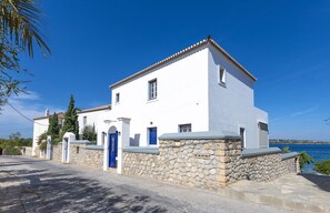 the house from the street with the  alley leading to the small beach