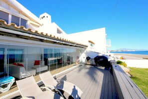 Outdoor terrace with sunloungers, barbecue area and access to the beach