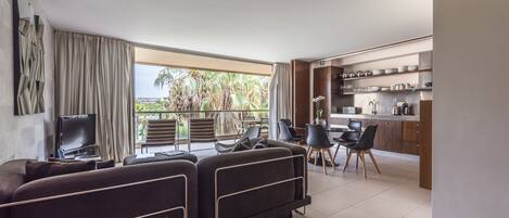 The living room, opening on the balcony, overlooks the pools.