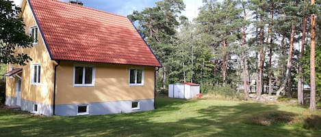 Hinteransicht des Hauses. Der Garten geht über in den Wald.
